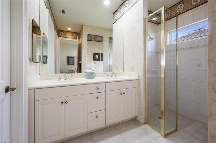 Guest Bathroom with walk in tile shower, dual sinks and large walk in closet