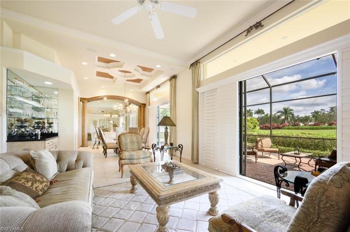 Living Room with Bar Area and Sliders to the Back Lanai with Golf Course and Lake Views