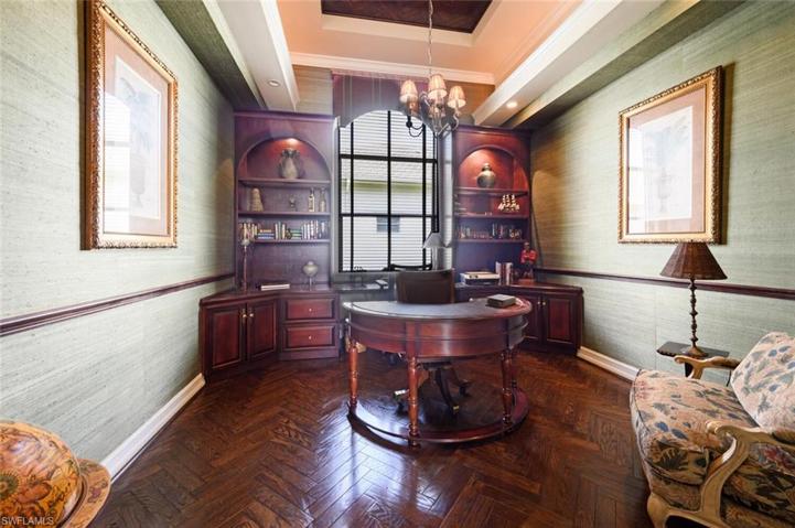 A well designed office with a built in desk , bookcases,  a free standing desk and reading chair
