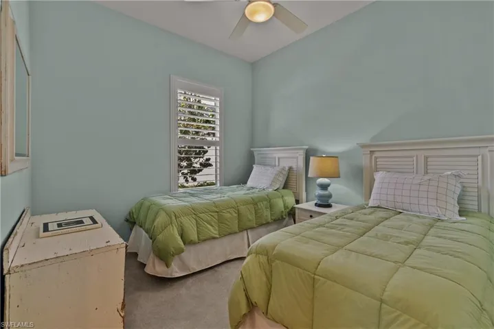 Carpeted bedroom featuring ceiling fan
