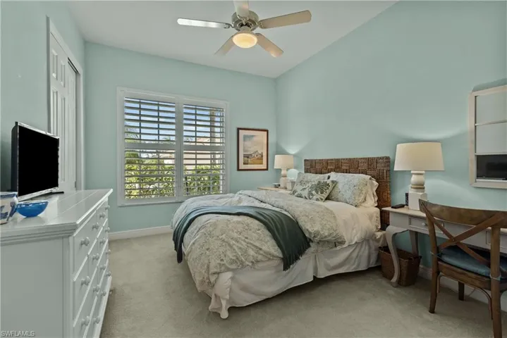 Carpeted bedroom with a closet and ceiling fan