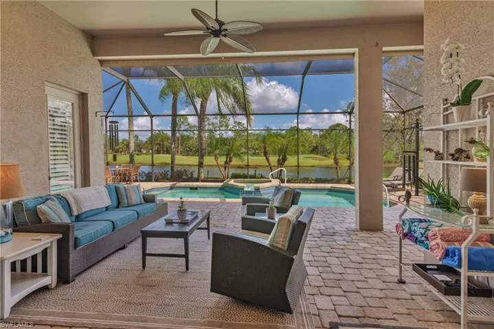 View of patio featuring an outdoor living space, a pool with hot tub, a water view, and glass enclosure