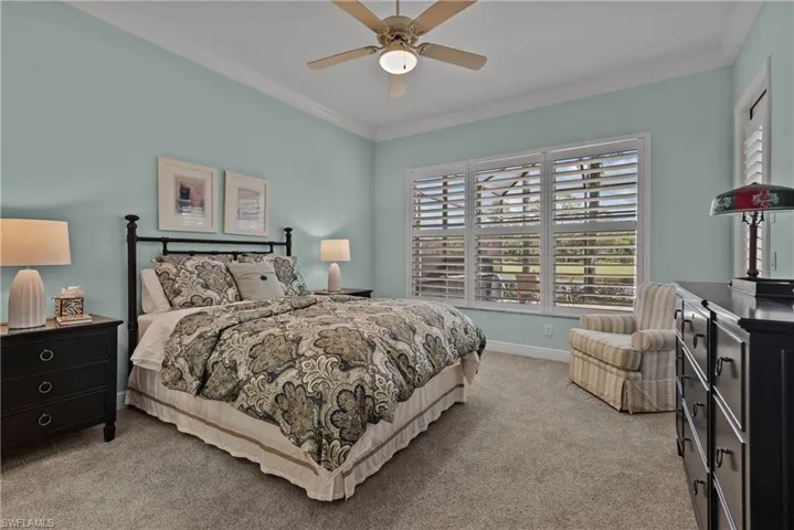 Bedroom with crown molding, light carpet, and ceiling fan