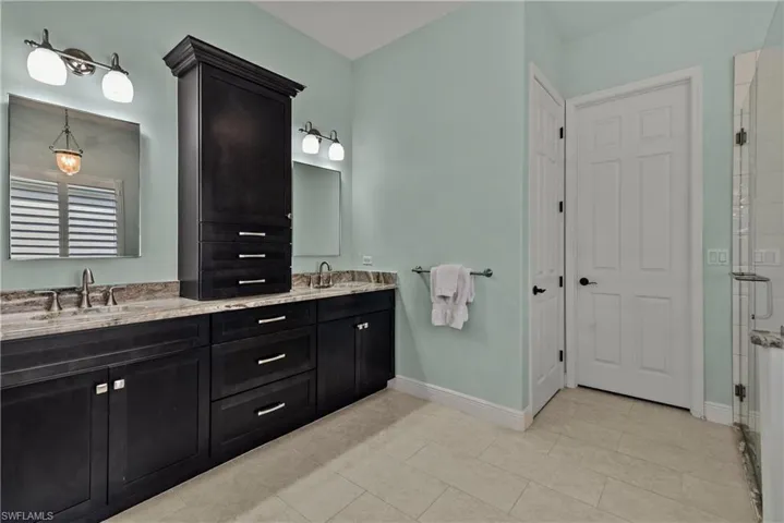 Bathroom featuring vanity, an enclosed shower, and tile patterned floors