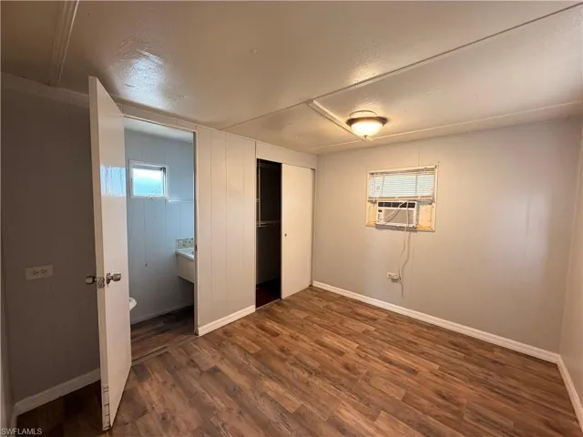Unfurnished bedroom with dark wood-style floors, a closet, and a textured ceiling