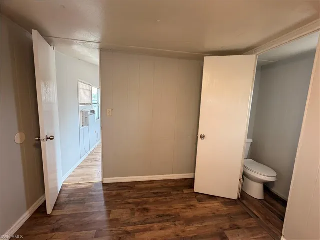 Half bathroom with dark wood-type flooring and cooling unit