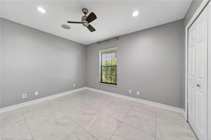 Unfurnished bedroom featuring ceiling fan, recessed lighting, a closet, and light marble finish flooring