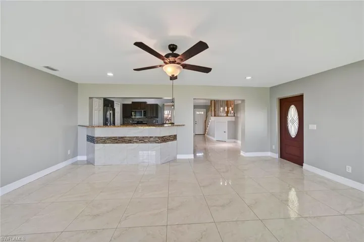 Unfurnished living room with ceiling fan and recessed lighting