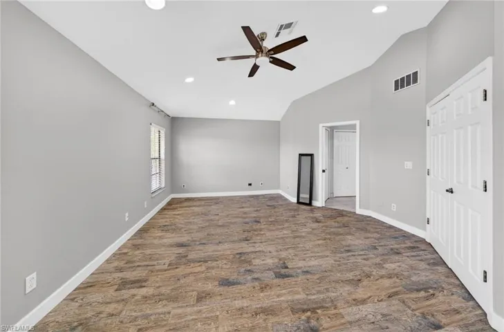 Unfurnished bedroom with dark wood-style floors, vaulted ceiling, ceiling fan, and recessed lighting