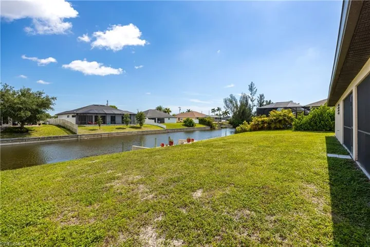 Expansive green lawn bordering a canal with seawall