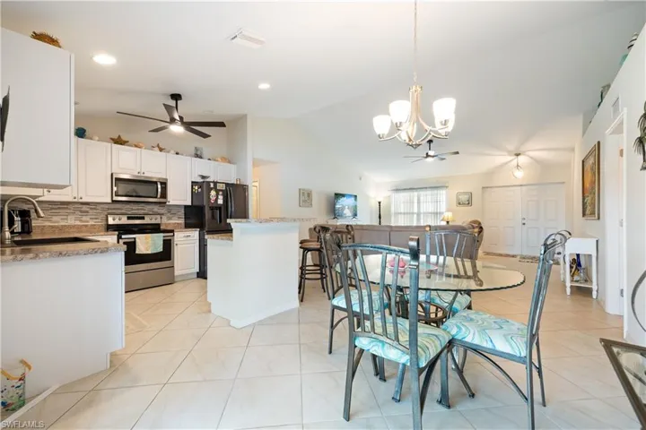 Kitchen with white cabinetry, stainless steel appliances, and a tiled backsplash
