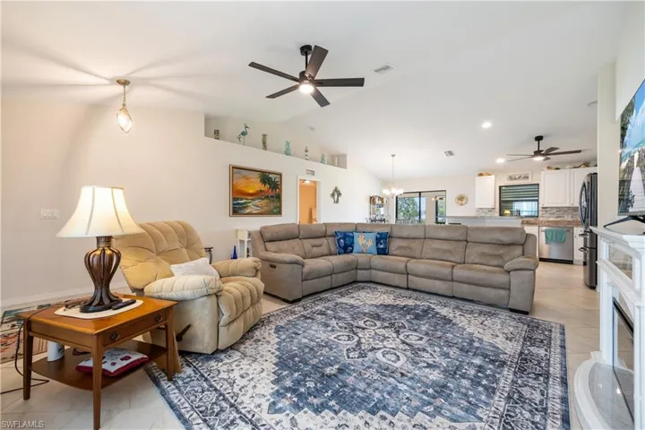 Open-concept interior featuring light tile flooring and vaulted ceilings