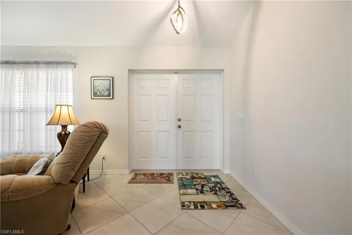Entryway featuring double panel doors, neutral wall tones, and tiled flooring