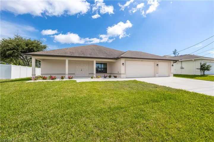 Contemporary ranch-style residence featuring a textured stucco exterior, an extended covered front porch, and a dual garage