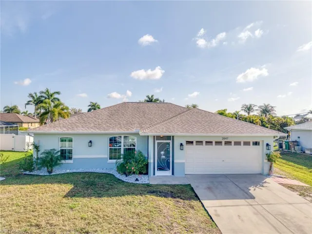 Ranch-style house with stucco siding, concrete driveway, an attached garage, and roof with shingles