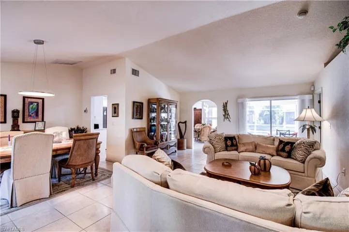 Living area with vaulted ceiling and light tile patterned floors