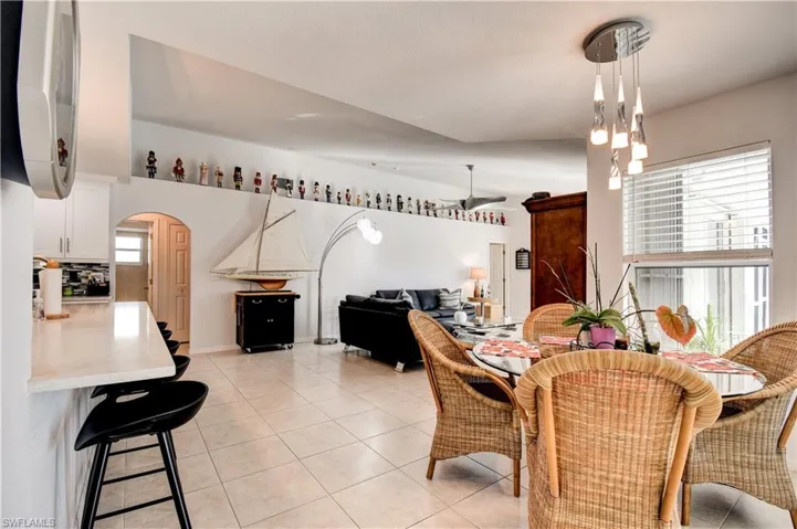 Dining space with arched walkways and light tile patterned floors
