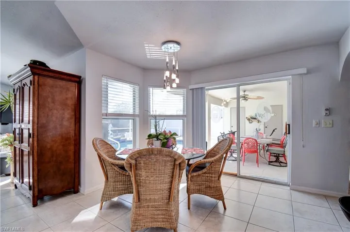 Dining room featuring light tile patterned flooring, a ceiling fan, a chandelier, and a textured ceiling