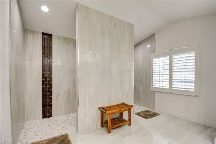 Bathroom featuring a walk in shower and tile walls