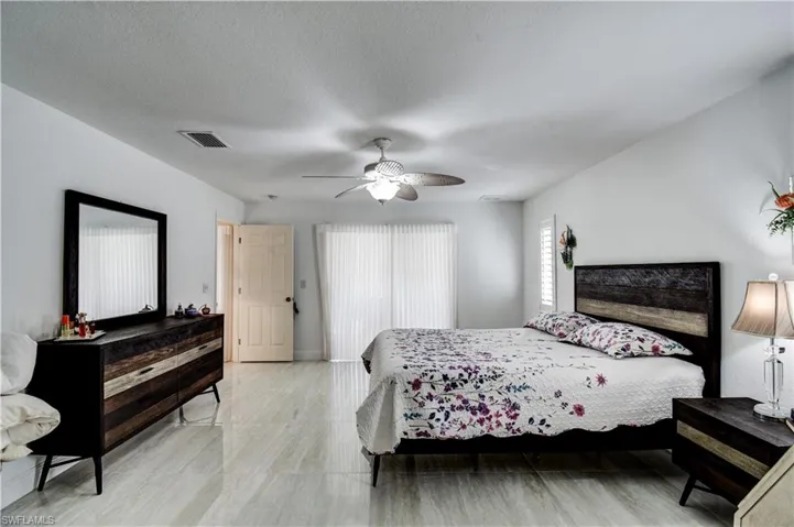 Bedroom with a ceiling fan and a textured ceiling