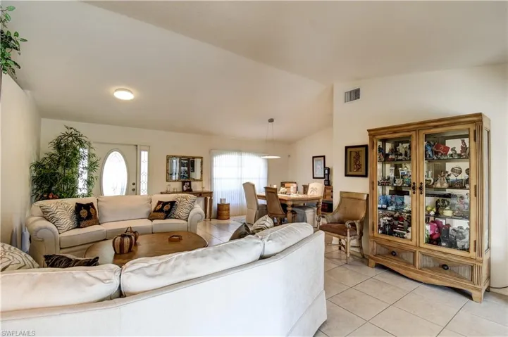 Living room with light tile patterned flooring and lofted ceiling