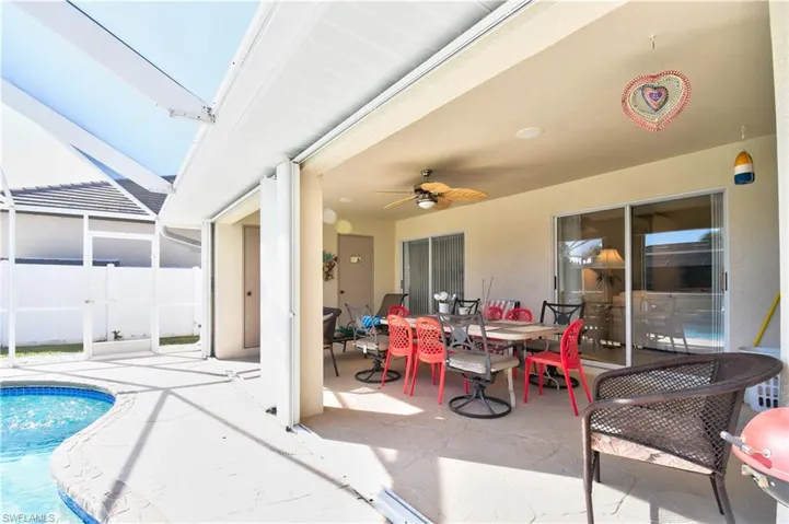 View of patio / terrace featuring outdoor dining area, ceiling fan, an outdoor pool, a sunroom, and glass enclosure