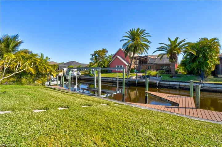 Dock area with a lawn, a water view, and boat lift