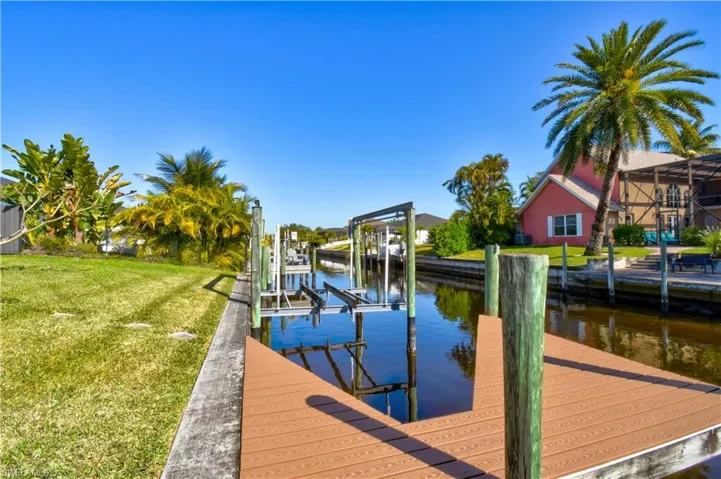 Dock featuring a water view, boat lift, and a yard