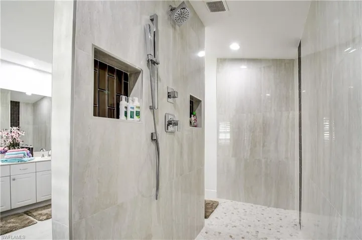 Bathroom featuring walk in shower, vanity, and recessed lighting