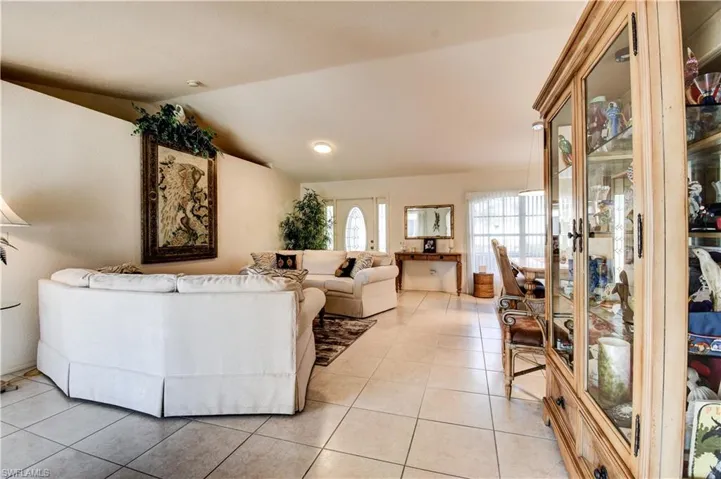 Living area with lofted ceiling and light tile patterned flooring