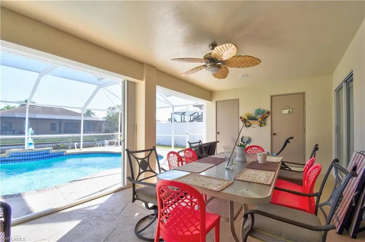 Sunroom featuring outdoor dining area, ceiling fan, and a patio area