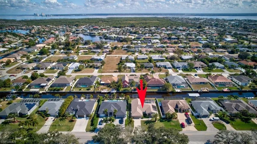 Aerial overview of property's location featuring a nearby body of water and nearby suburban area
