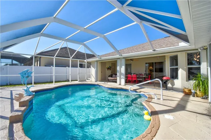 View of pool with glass enclosure, a patio area, and a sunroom