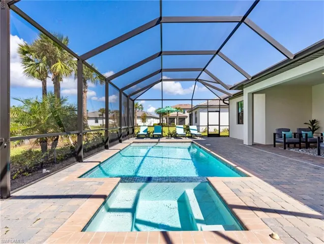 View of pool featuring a patio area and glass enclosure