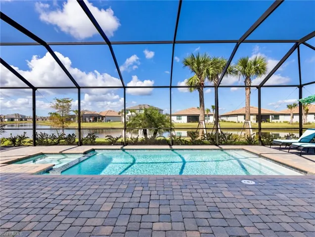 View of swimming pool with a patio, an in ground hot tub, a water view, and a lanai