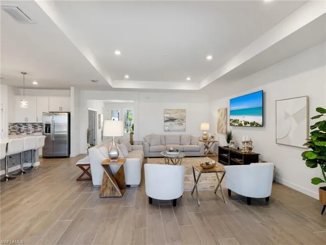 Living room featuring light hardwood / wood-style flooring and a tray ceiling