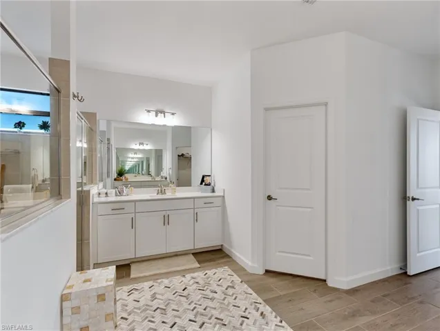 Bathroom with vanity, hardwood / wood-style flooring, and walk in shower