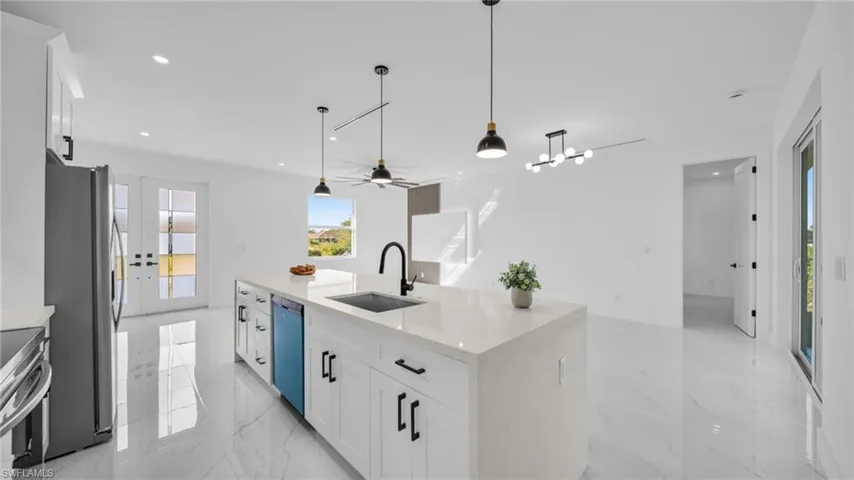 Kitchen featuring white cabinetry, light stone countertops, light marble finish floors, and recessed lighting