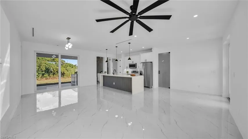 Unfurnished living room featuring recessed lighting, light marble finish flooring, and ceiling fan