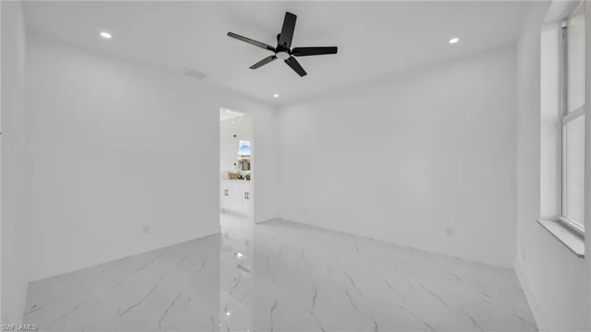 Empty room with light marble finish floors, recessed lighting, and a ceiling fan