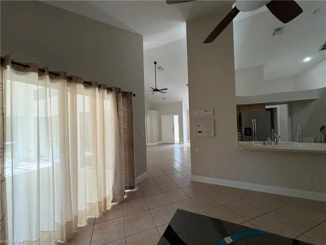 Hall featuring light tile patterned floors and high vaulted ceiling