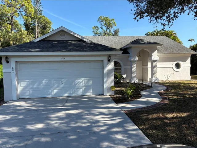 Ranch-style house with roof with shingles, driveway, and a garage