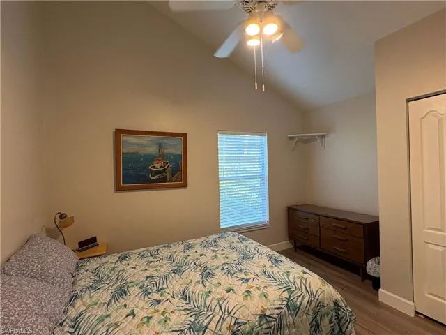 Bedroom with lofted ceiling, ceiling fan, and dark wood finished floors