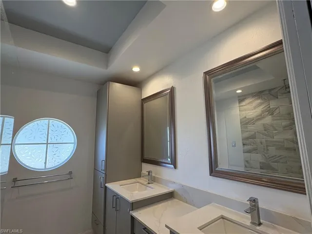 Full bathroom with double vanity and recessed lighting