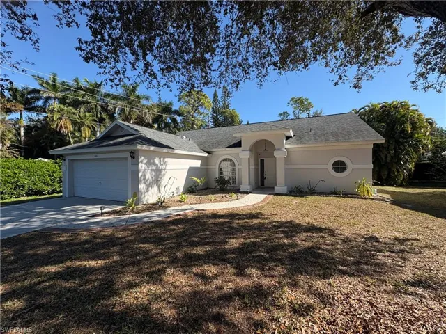 Single story home featuring concrete driveway, a front yard, an attached garage, and stucco siding
