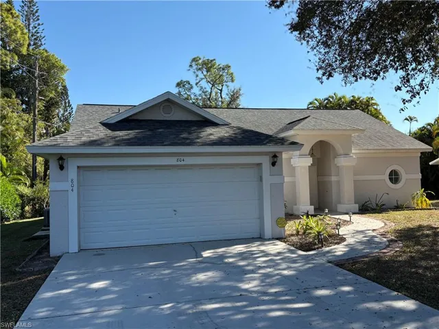 Single story home featuring a shingled roof, driveway, stucco siding, and a garage