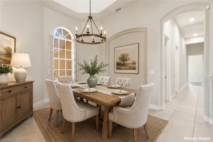 Dining area featuring a tray ceiling and a rustic chandelier