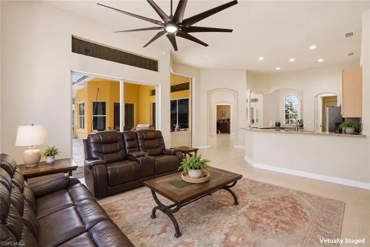 Spacious open-concept living area with high ceilings, recessed lighting, and a modern ceiling fan