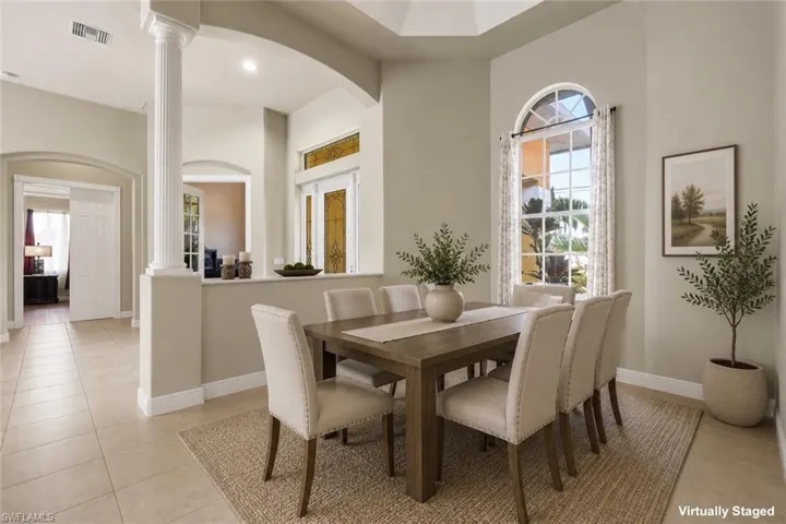 Dining area featuring a tray ceiling and arched window