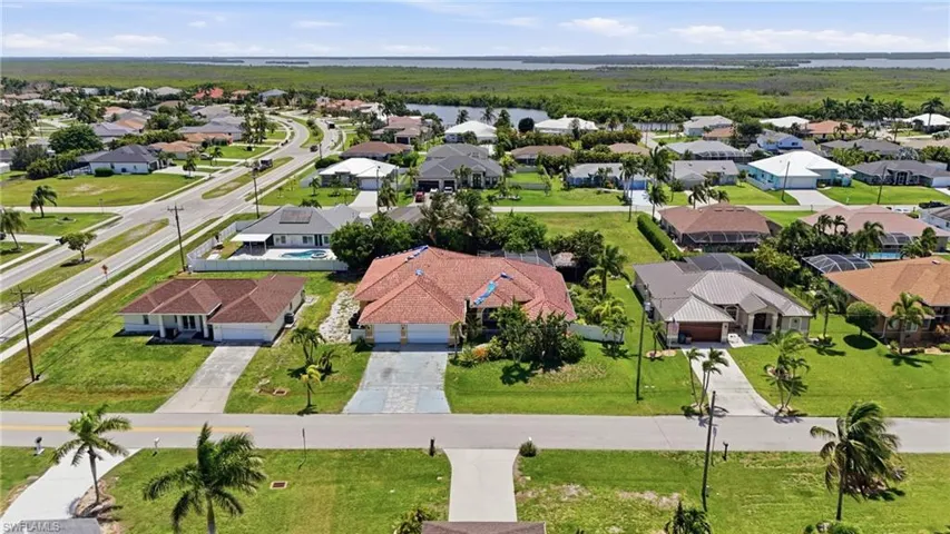 Residential neighborhood featuring single-story homes with varied rooflines, paved driveways, and mature landscaping